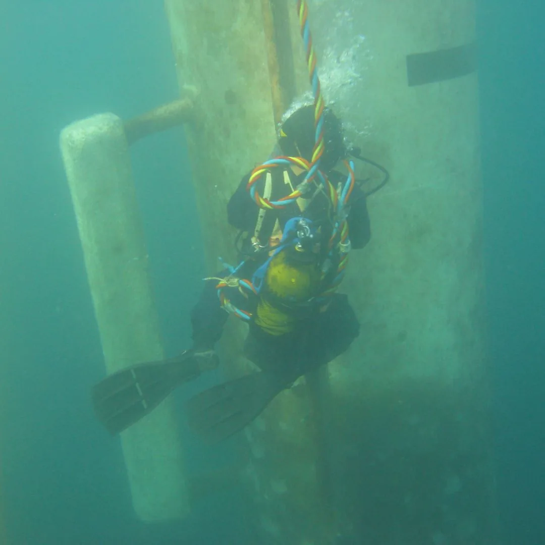 Commercial diver working beside a submerged structure